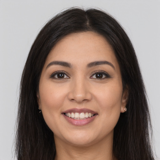 Joyful latino young-adult female with long  brown hair and brown eyes
