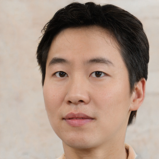 Joyful asian young-adult male with short  brown hair and brown eyes