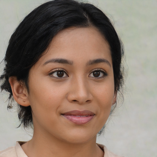 Joyful latino young-adult female with medium  brown hair and brown eyes