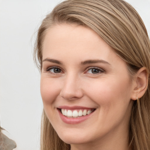 Joyful white young-adult female with long  brown hair and brown eyes