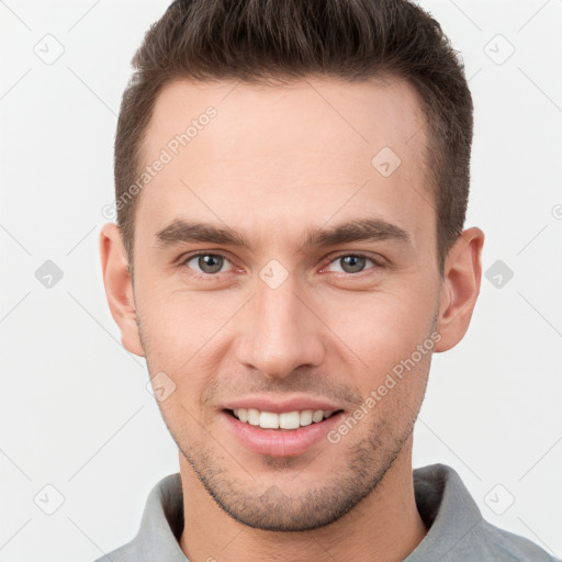 Joyful white young-adult male with short  brown hair and grey eyes