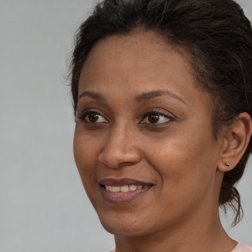 Joyful black young-adult female with medium  brown hair and brown eyes
