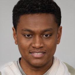 Joyful black young-adult male with short  brown hair and brown eyes