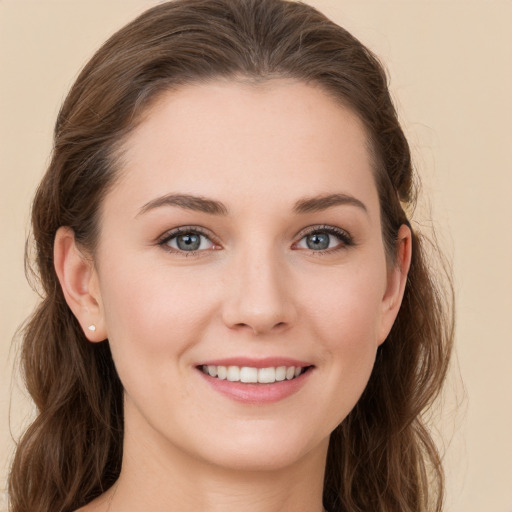 Joyful white young-adult female with long  brown hair and green eyes