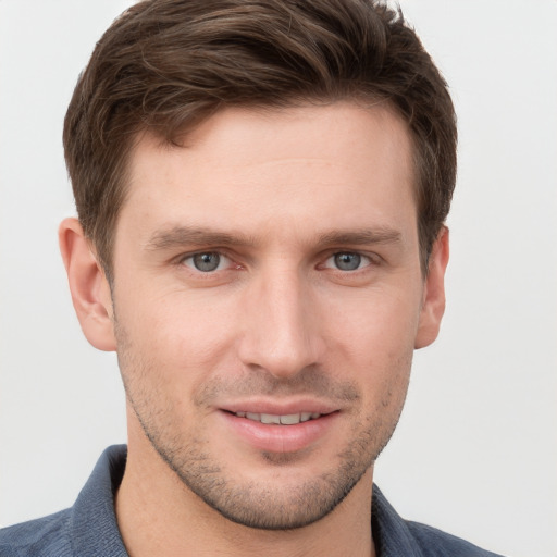 Joyful white young-adult male with short  brown hair and grey eyes