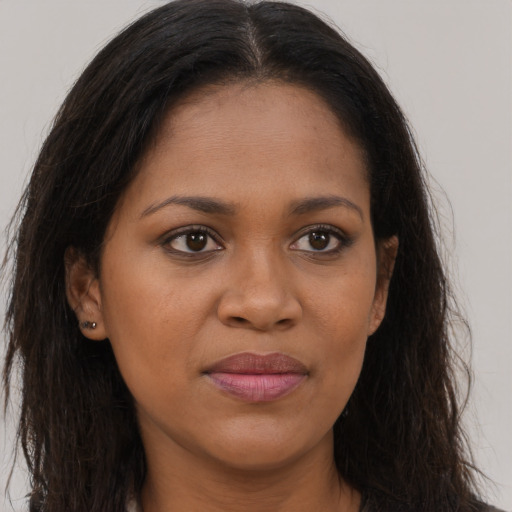 Joyful black young-adult female with long  brown hair and brown eyes
