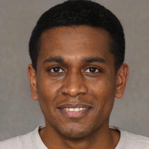 Joyful black young-adult male with short  black hair and brown eyes