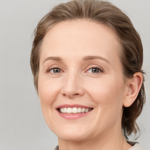 Joyful white young-adult female with medium  brown hair and grey eyes