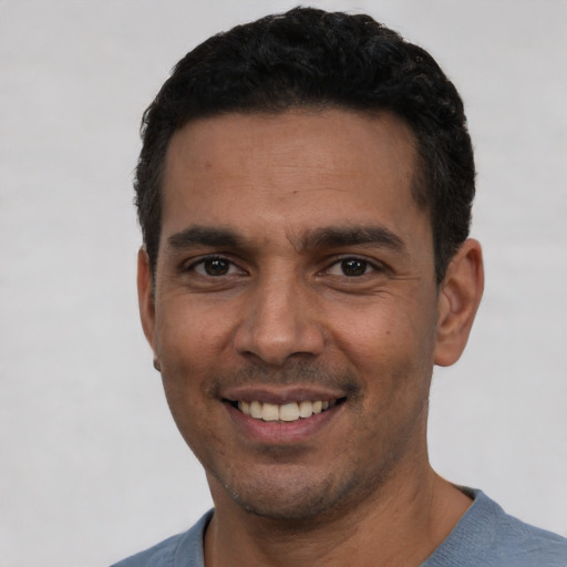 Joyful white young-adult male with short  black hair and brown eyes