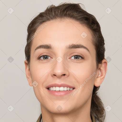 Joyful white young-adult female with medium  brown hair and grey eyes