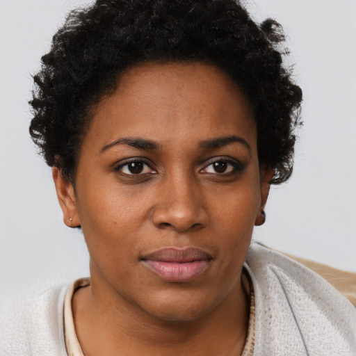 Joyful black young-adult female with short  brown hair and brown eyes