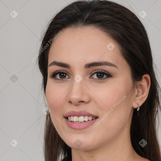 Joyful white young-adult female with long  brown hair and brown eyes