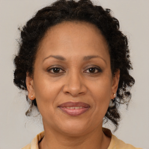 Joyful black adult female with medium  brown hair and brown eyes