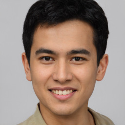 Joyful latino young-adult male with short  brown hair and brown eyes