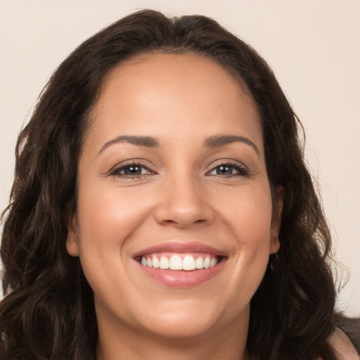 Joyful white young-adult female with long  brown hair and brown eyes