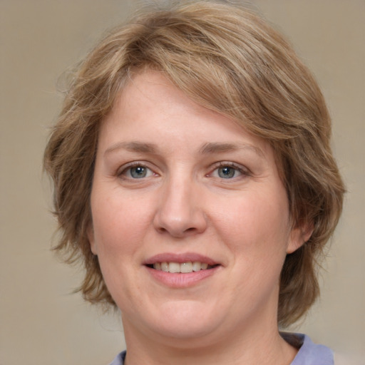 Joyful white adult female with medium  brown hair and blue eyes