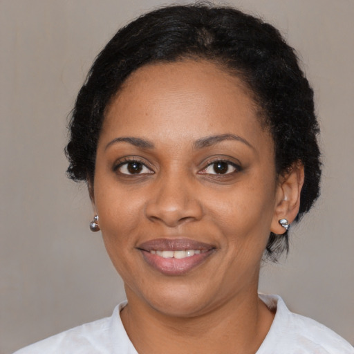 Joyful black adult female with short  black hair and brown eyes