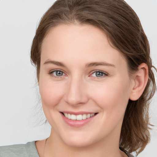 Joyful white young-adult female with medium  brown hair and blue eyes