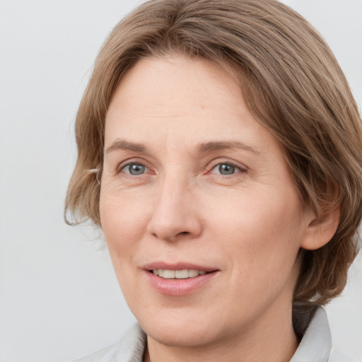 Joyful white adult female with medium  brown hair and grey eyes