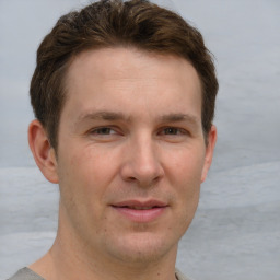 Joyful white adult male with short  brown hair and grey eyes