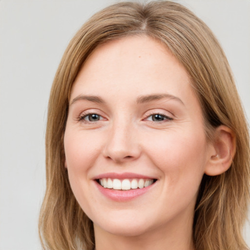 Joyful white young-adult female with long  brown hair and green eyes