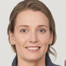 Joyful white young-adult female with medium  brown hair and grey eyes