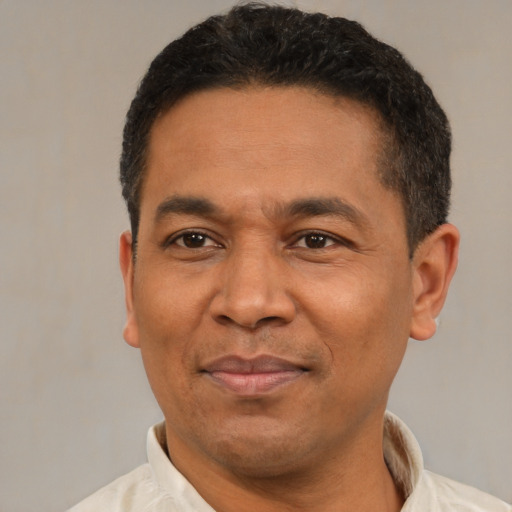 Joyful latino adult male with short  black hair and brown eyes