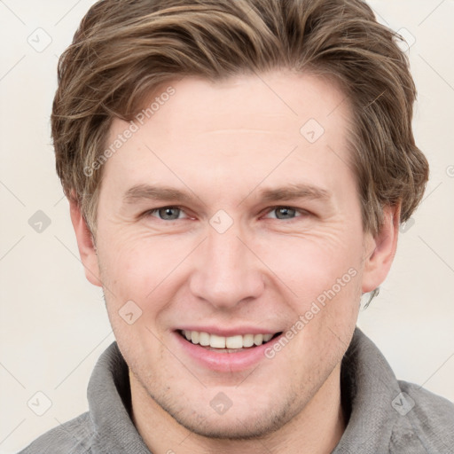 Joyful white adult male with short  brown hair and grey eyes