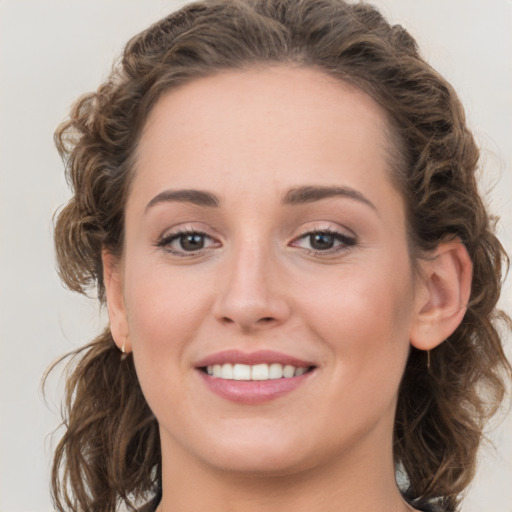 Joyful white young-adult female with medium  brown hair and blue eyes