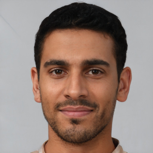 Joyful latino young-adult male with short  black hair and brown eyes