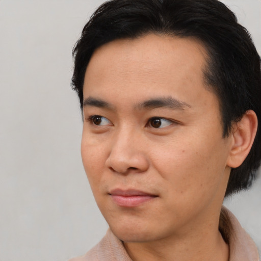 Joyful asian young-adult male with short  black hair and brown eyes