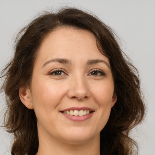 Joyful white young-adult female with long  brown hair and brown eyes