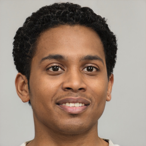 Joyful black young-adult male with short  brown hair and brown eyes