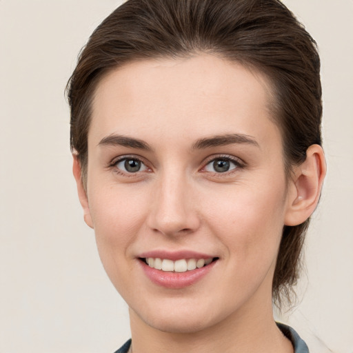 Joyful white young-adult female with short  brown hair and grey eyes