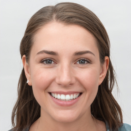 Joyful white young-adult female with medium  brown hair and grey eyes