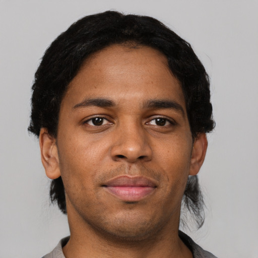 Joyful black young-adult male with short  black hair and brown eyes