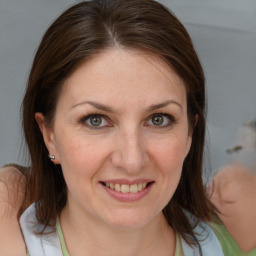 Joyful white young-adult female with medium  brown hair and blue eyes