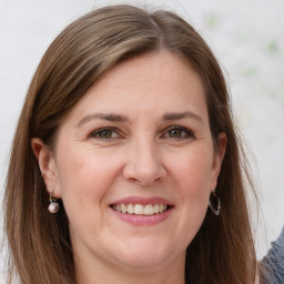 Joyful white adult female with long  brown hair and grey eyes