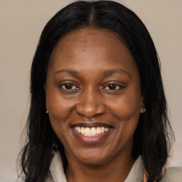 Joyful black adult female with medium  brown hair and brown eyes