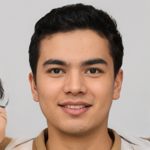 Joyful latino young-adult male with short  brown hair and brown eyes