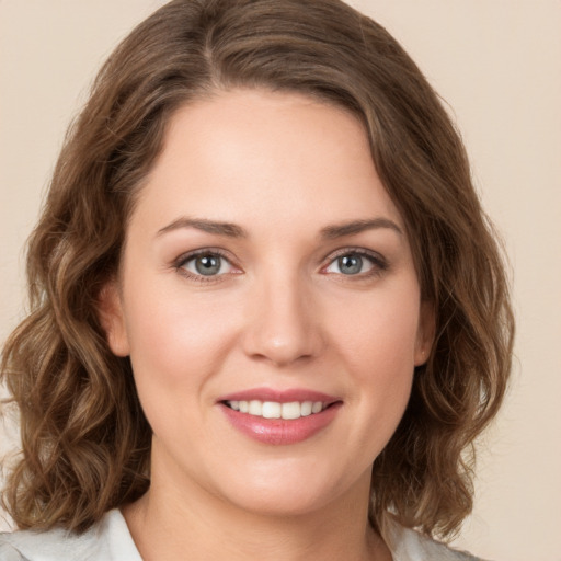 Joyful white young-adult female with medium  brown hair and green eyes