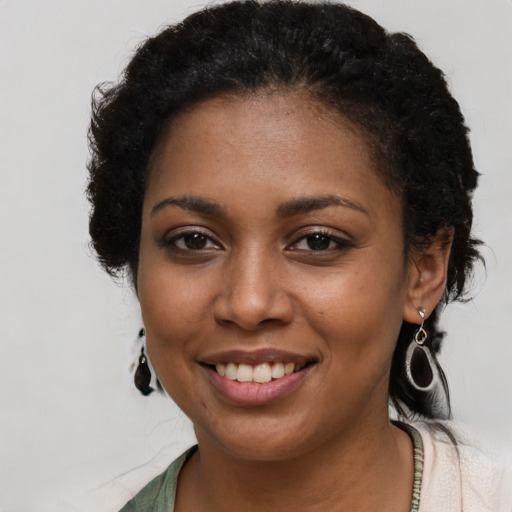Joyful black young-adult female with long  black hair and brown eyes
