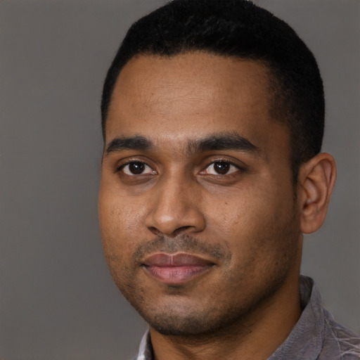 Joyful black young-adult male with short  black hair and brown eyes