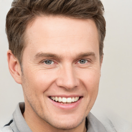 Joyful white adult male with short  brown hair and grey eyes