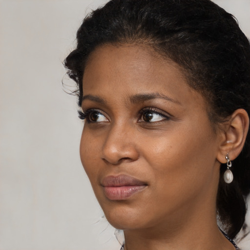 Joyful black young-adult female with medium  brown hair and brown eyes