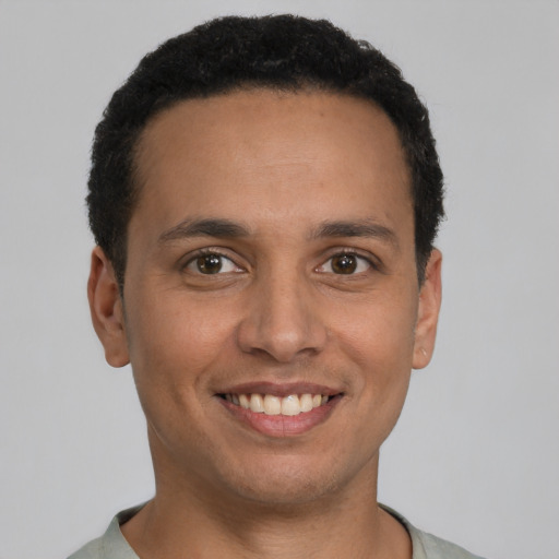 Joyful latino young-adult male with short  brown hair and brown eyes