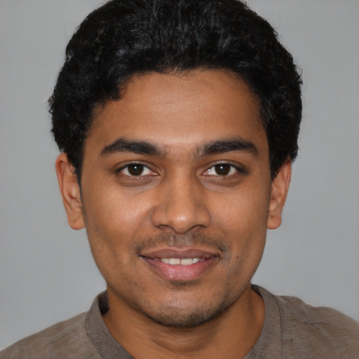 Joyful latino young-adult male with short  black hair and brown eyes