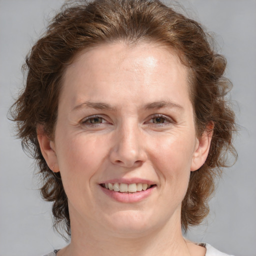 Joyful white adult female with medium  brown hair and blue eyes