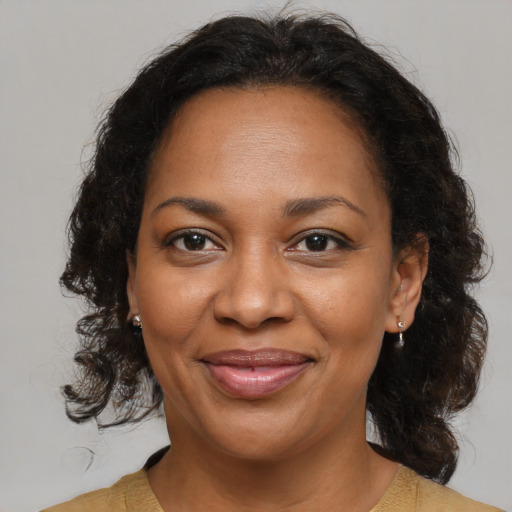 Joyful black adult female with medium  brown hair and brown eyes