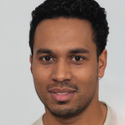 Joyful latino young-adult male with short  black hair and brown eyes